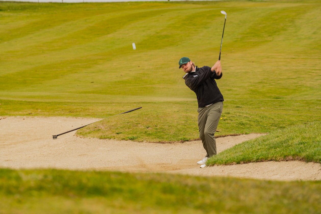 Golfaaja lyö palloa bunkkerista